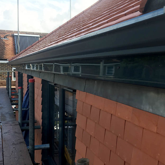 Black Seamless Guttering Being Installed on Commercial Property